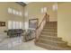 Spacious living room with staircase, sleek furniture, and lots of natural light through shuttered windows at 7613 Hackensack Ct, Las Vegas, NV 89128