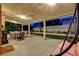 Charming outdoor patio at twilight, featuring cozy seating, a fireplace, and a view of the beautifully landscaped backyard at 7613 Hackensack Ct, Las Vegas, NV 89128