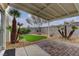 Lush backyard with artificial grass and covered patio, perfect for relaxation or entertainment at 8121 Heavenly Star Cir, Las Vegas, NV 89128