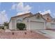 Charming home featuring a two-car garage, stucco exterior, and red rock landscaping at 8121 Heavenly Star Cir, Las Vegas, NV 89128