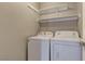 Functional laundry room with washer, dryer, and shelving for organized storage at 8121 Heavenly Star Cir, Las Vegas, NV 89128