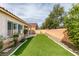Expansive backyard with synthetic grass, mature trees and desert plants for a lush, easy-care landscape at 8232 Sedona Sunset Dr, Las Vegas, NV 89128