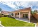 Lush backyard featuring synthetic grass, a covered patio, and mature landscaping for outdoor enjoyment at 8232 Sedona Sunset Dr, Las Vegas, NV 89128