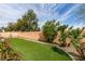 Beautifully landscaped backyard with synthetic grass and mature desert plants, providing a low-maintenance outdoor space at 8232 Sedona Sunset Dr, Las Vegas, NV 89128