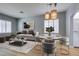 Open dining area with modern pendant lighting and light wood floors, with sitting area in background at 8232 Sedona Sunset Dr, Las Vegas, NV 89128