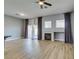 Open living room with fireplace, wood floors, ceiling fan, and sliding glass doors at 8232 Sedona Sunset Dr, Las Vegas, NV 89128