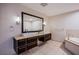 Modern bathroom features a double sink vanity, large mirror, and soaking tub for a spa-like experience at 8925 W Flamingo Rd # 228, Las Vegas, NV 89147