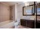 Bathroom featuring tiled shower over tub, floating vanity with marble countertop, and unique mirror at 8925 W Flamingo Rd # 228, Las Vegas, NV 89147