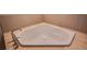 Corner bathtub with stone tile surround and modern faucet at 8925 W Flamingo Rd # 228, Las Vegas, NV 89147