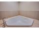 Corner bathtub with stone tile surround and modern faucet at 8925 W Flamingo Rd # 228, Las Vegas, NV 89147