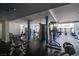 A spacious gym featuring modern exercise equipment, a black rubber floor, with natural light, and blue support beams at 8925 W Flamingo Rd # 228, Las Vegas, NV 89147