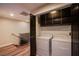 Laundry room with dark wood cabinets, washer, dryer and door to the stairwell at 8925 W Flamingo Rd # 228, Las Vegas, NV 89147