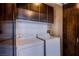 The laundry room offers upper cabinets and modern, efficient washer and dryer units at 8925 W Flamingo Rd # 228, Las Vegas, NV 89147
