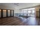 Bright living room featuring hardwood floors, ceiling fan, large windows, and glass railing at 8925 W Flamingo Rd # 228, Las Vegas, NV 89147