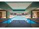 A long indoor lap pool with sun loungers and umbrellas, providing a refreshing escape at 8925 W Flamingo Rd # 228, Las Vegas, NV 89147