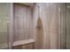 Walk-in shower featuring light stone tile, a built-in bench, and a rainfall showerhead at 8925 W Flamingo Rd # 228, Las Vegas, NV 89147
