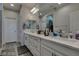 Ensuite bathroom with dual sink vanity, white cabinets, and wood look floors at 8977 Sweet Chestnut Ln, Las Vegas, NV 89178
