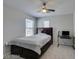 Comfortable bedroom with a dark wood bed frame and computer desk under a ceiling fan at 8977 Sweet Chestnut Ln, Las Vegas, NV 89178