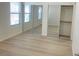 Sunlit bedroom with wood-look floors, windows, and mirrored sliding closet doors at 8985 S Durango Dr # 2043, Las Vegas, NV 89113