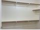 Neutral walk-in closet features white walls, wooden shelves, and baseboards at 8985 S Durango Dr # 2043, Las Vegas, NV 89113