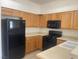 Kitchen with black appliances, light wood cabinets, and neutral countertops at 8985 S Durango Dr # 2043, Las Vegas, NV 89113