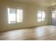 Bright living room featuring wood-look floors and lots of natural light through the two large windows at 8985 S Durango Dr # 2043, Las Vegas, NV 89113