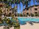 Sparkling community pool surrounded by mature landscaping and comfortable lounge chairs for relaxation at 8985 S Durango Dr # 2043, Las Vegas, NV 89113