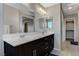 Bathroom with dark cabinets, double sinks, a large mirror, and tile floors at 9050 W Tropicana Ave # 1080, Las Vegas, NV 89147