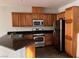 Kitchen with stainless steel appliances, brown cabinets, and tile floors at 10067 Sand Key St, Las Vegas, NV 89178