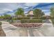 Inviting community entrance with lush landscaping, decorative signage, and well-maintained sidewalks at 10808 Wallflower Ave, Las Vegas, NV 89135