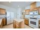 Well-lit kitchen featuring light wood cabinets, tiled floors, and an island with ample counter space at 10808 Wallflower Ave, Las Vegas, NV 89135