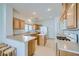Well-lit kitchen featuring light wood cabinets, tiled floors, and an island with additional counter space at 10808 Wallflower Ave, Las Vegas, NV 89135