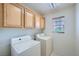 Functional laundry room featuring modern washer and dryer, ample cabinet space, and a window at 10808 Wallflower Ave, Las Vegas, NV 89135