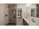 Jack and Jill bathroom featuring double sinks, modern lighting, and a spacious tiled shower at 18 Placa De Rei Ct, Henderson, NV 89011