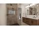Jack & Jill bath boasts a large mirror with vanity lighting, double sinks, and tile enclosed shower at 18 Placa De Rei Ct, Henderson, NV 89011