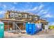 New construction exterior featuring a large blue dumpster and construction materials in front, in a developing residential area at 18 Placa De Rei Ct, Henderson, NV 89011