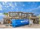 New construction exterior with a blue dumpster in front, showcasing the home's modern facade and ongoing development at 18 Placa De Rei Ct, Henderson, NV 89011