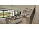 Open-concept living space with stairs, living room, dining area, modern kitchen with island, and backyard view at 18 Placa De Rei Ct, Henderson, NV 89011