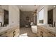 Well-lit primary bath with dual vanities, sleek fixtures, a soaking tub, and walk-in shower at 18 Placa De Rei Ct, Henderson, NV 89011