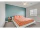 Bright bedroom featuring an accent wall and a bed with a white frame and orange patterned bedding at 5742 Shadow Bend Dr, Las Vegas, NV 89135