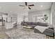 Open-concept living room boasts modern design with sleek ceiling fan and a large comfortable gray sofa at 5742 Shadow Bend Dr, Las Vegas, NV 89135