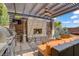 Outdoor living area featuring a stone fireplace, grill, and comfortable seating under a pergola at 5742 Shadow Bend Dr, Las Vegas, NV 89135