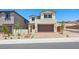 Inviting two-story home with a paver driveway, desert landscaping, and a neutral color scheme at 74 Via Montoro, Henderson, NV 89011