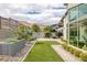 This backyard features a brick patio, small patch of grass, desert landscaping, and a mountain view at 10271 Meridian Hill Ave, Las Vegas, NV 89135