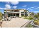 This backyard features a brick patio, small patch of grass, and desert landscaping at 10271 Meridian Hill Ave, Las Vegas, NV 89135