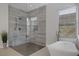 Modern bathroom featuring a walk-in shower, soaking tub, and sleek design with large tiles and natural light at 10271 Meridian Hill Ave, Las Vegas, NV 89135