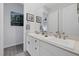 Bright bathroom with double sinks, white cabinetry, decorative mirrors, and wood-look flooring at 10271 Meridian Hill Ave, Las Vegas, NV 89135