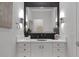 Modern bathroom features a black patterned accent wall, a large mirror, and a white vanity with gold hardware at 10271 Meridian Hill Ave, Las Vegas, NV 89135