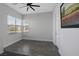 Bright bedroom with wood-look floors, a ceiling fan, and large windows for ample natural light at 10271 Meridian Hill Ave, Las Vegas, NV 89135