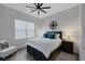 Cozy bedroom featuring a queen-size bed, stylish decor, a ceiling fan, and wood-look flooring at 10271 Meridian Hill Ave, Las Vegas, NV 89135